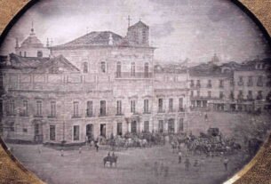 Daguerreótipo histórico do Paço Imperial, no Rio de Janeiro, com pessoas e cavalos diante do edifício.