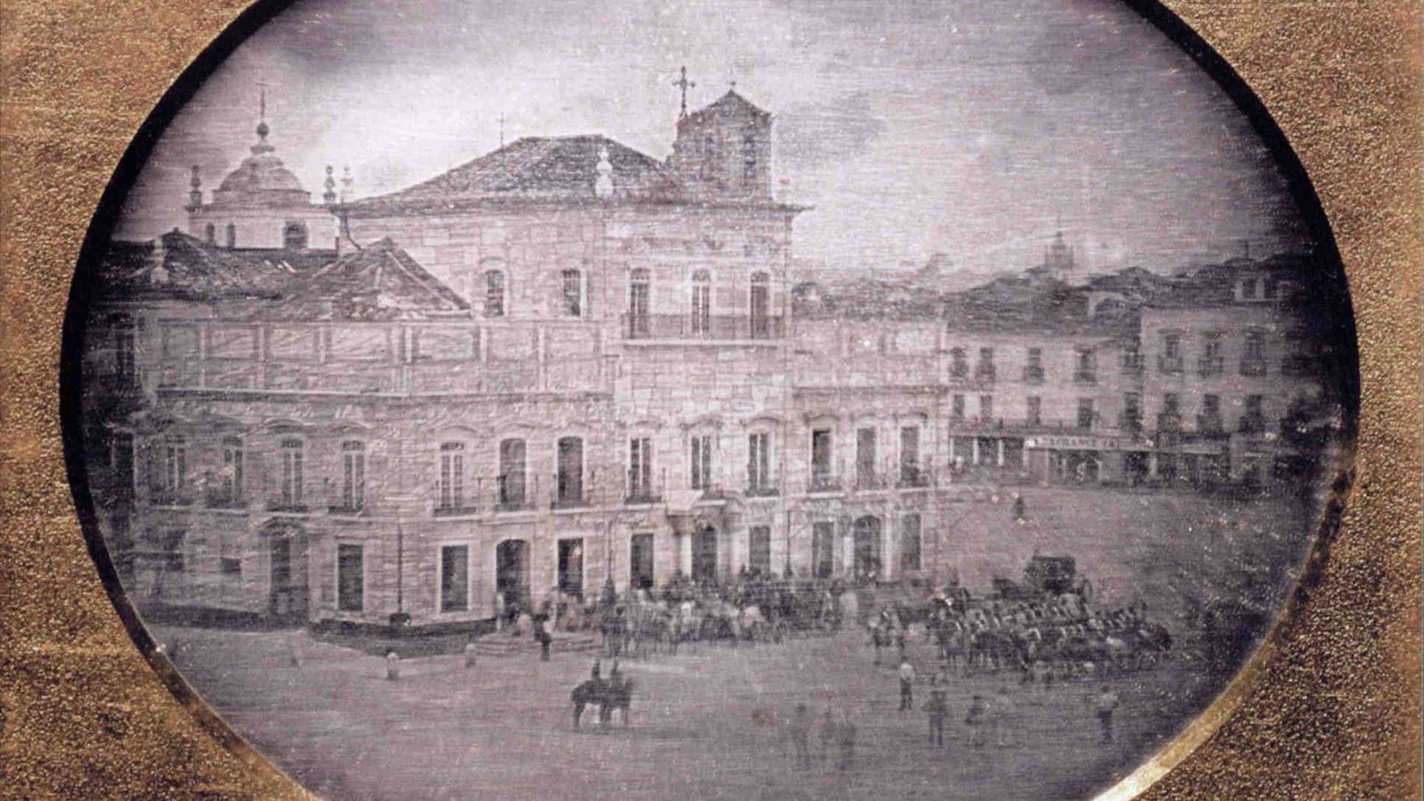 Daguerreótipo histórico do Paço Imperial, no Rio de Janeiro, com pessoas e cavalos diante do edifício.