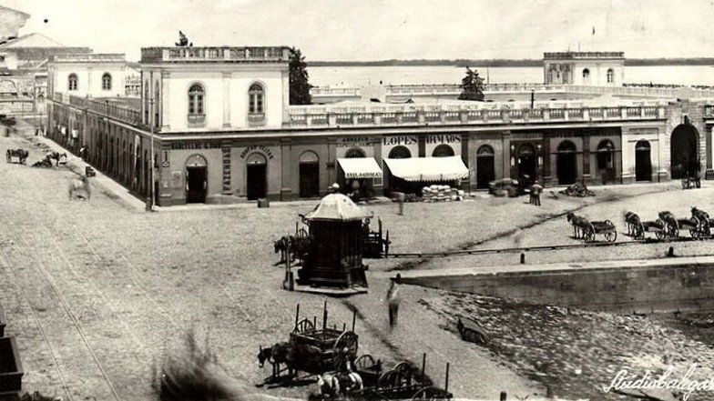 Vista do Mercado Público de Porto Alegre, por volta de 1890, com carroças e circulação no entorno., em fotografia de Virgílio Calegari, c. 1890.